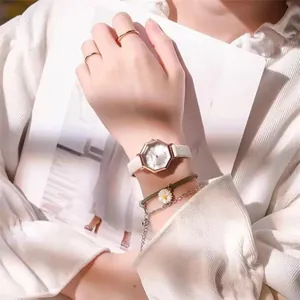 Elegant octagon rose gold watch with white leather strap shown on a woman wrist