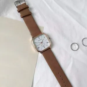 Detail of vintage square quartz watch with rose gold case and brown leather strap