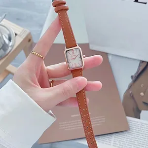 Detailopname van vierkant kwartshorloge met bruine leren band en roségouden kast