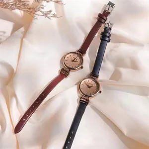 Detailansicht eleganter Damenuhren mit Lederarmbändern auf einem Seidenhintergrund