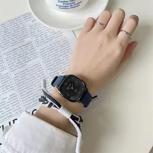 Details einer quadratischen schwarzen Quartzuhr mit dunkelblauem Lederarmband