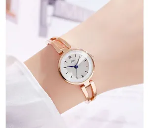 Detalle de reloj de pulsera oro rosa con agujas azules y esfera elegante marca jw