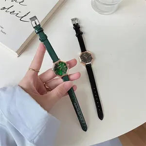Detail of octagonal quartz watches with green and black leather straps on a wrist
