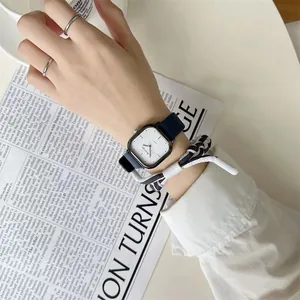 Nahaufnahme einer quadratischen Silberquarzuhr mit schmalem dunklem Lederband am Handgelenk