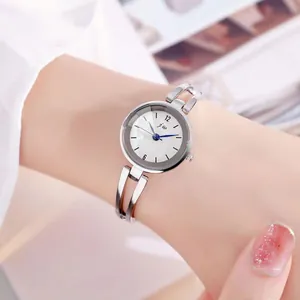 Elegante reloj de pulsera plateado con esfera blanca y agujas azules de estilo minimalista