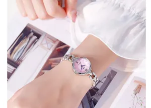 Gros plan détaillé d'une montre à quartz argentée avec cadran rose et index en cristaux