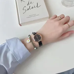 Detail of octagon rose gold watch with black leather strap and daisy bracelet set