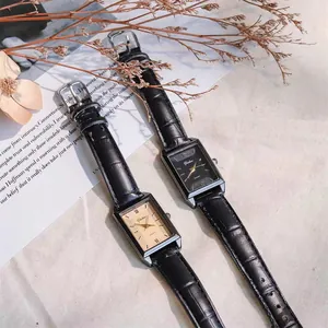 Close-up of rectangular quartz watch with Roman numerals and black croc-leather strap