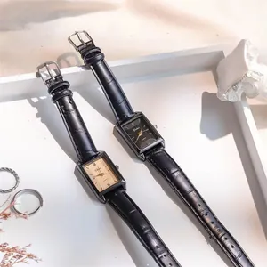 Close-up of vintage rectangular quartz watches with leather straps and Roman numerals