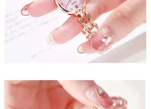 Détail d'une montre bracelet rose doré avec cadran rose et chiffres romains
