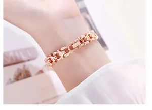 Gros plan d'un bracelet de montre à maillons H en or rose élégant pour femmes