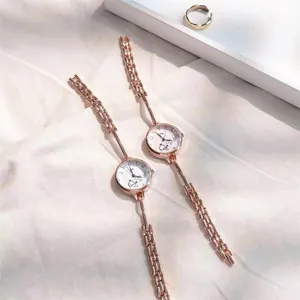 Dettaglio orologio al quarzo in oro rosa con cinturino a catena sottile e quadrante tondo