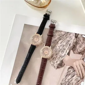 Close-up of elegant rhinestone-studded quartz watches with black and brown leather straps