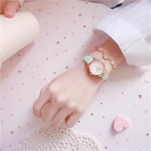 Detail of rose gold ladies quartz watch with light green leather strap and heart bracelet