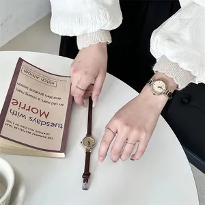 Primer plano de relojes de cuarzo retro para mujer con correas finas de cuero y caja dorada