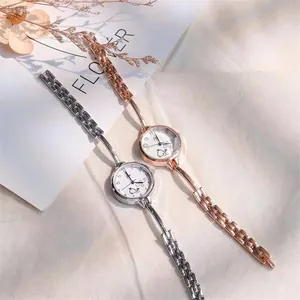 Dettaglio di orologi sottili da donna oro rosa e argento con motivo di cagnolino