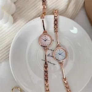 Detail von eleganten roségoldenen Quarzuhren mit Strass-Lünette auf einem Zierteller