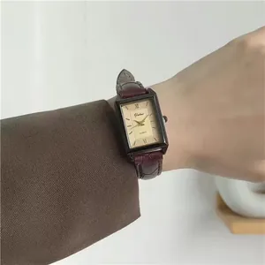 Elegant rectangular quartz watch with burgundy leather strap on wrist