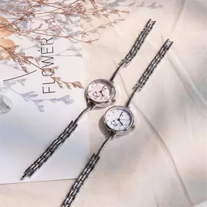 Dettaglio di due eleganti orologi da donna con cinturini sottili in metallo e quadranti con decori