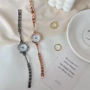 Nahaufnahme modischer Damenquarzuhren in Silber und Roségold mit schmalen Metallarmbändern