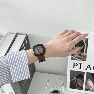 Macro-opname van een vierkant horloge met bruine siliconen band om een pols