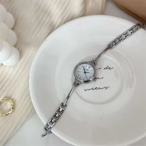 Detailansicht einer Damen-Armbanduhr in Silber mit Kettenarmband und weißem Zifferblatt