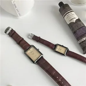 Detailed flat lay of rectangular quartz watches with brown leather straps and Roman numerals
