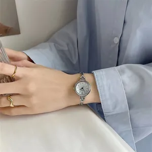 Nahaufnahme einer minimalistischen silbernen Quarzuhr mit feinem Metallarmband am Handgelenk