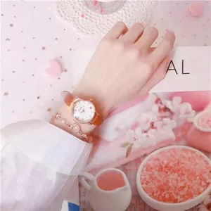 Close-up of elegant women's heart watch with leather strap and pearl bracelet set