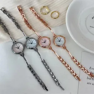 Makroaufnahme von vier eleganten Quarzuhren mit schmalen Metallkettenarmbändern und Diamanten