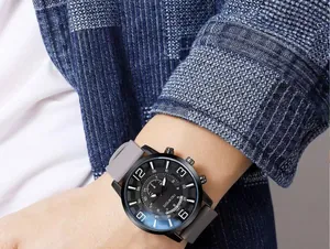 Close-up of a large black dial quartz watch with gray silicone strap on a male wrist