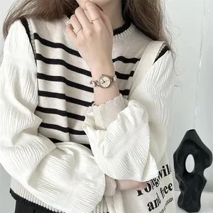 Detalle de elegante reloj de cuarzo en oro rosa en muñeca con anillos sencillos