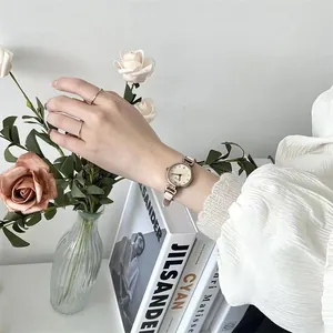 Reloj retro con correa de cuero beige y set de anillos dorados minimalistas