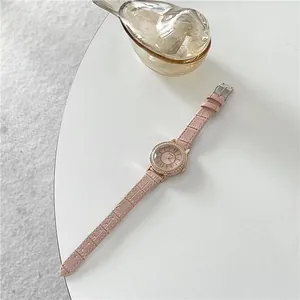 Close-up of pink faux-leather watch strap with rose gold rhinestone bezel and Roman dial