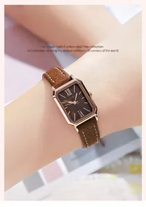 Gros plan d'une montre rectangulaire en or rose avec bracelet en cuir marron