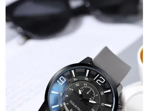 Macro side view of a modern large dial watch with grey silicone strap and urban accessories