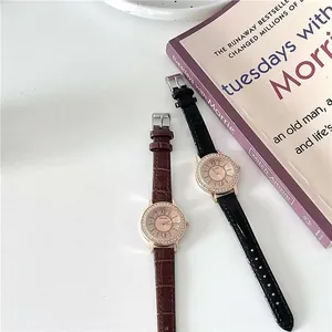 Detail of elegant rhinestone quartz watches with leather straps on a book background
