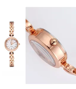 Détails d'une montre à quartz or rose avec petit cadran blanc et couronne citrouille