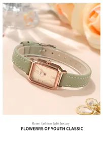 Détail de montre rectangulaire or rose avec bracelet cuir vert et cadran champagne