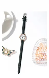 Détail d'une montre vintage pour femme avec bracelet en cuir noir et cadran or rose