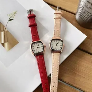 Twee retro dameshorloges in tonneau-vorm met roségouden kasten en bandjes met leertextuur