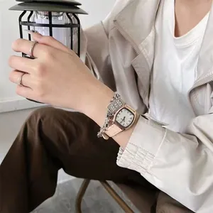 Retro horloge met beige lederen band en roségouden kast om de pols van het model