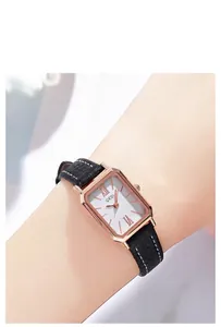 Montre femme rectangulaire élégante avec boîtier or rose et bracelet cuir noir au poignet