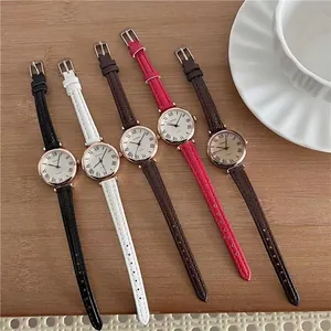 Detailed view of five vintage small-dial women's watches with leather straps on a wooden table