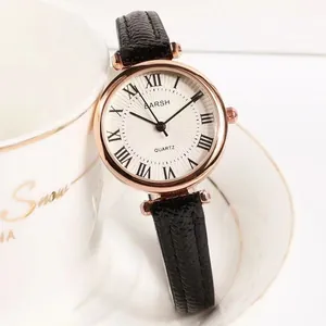 Detail of retro small dial watch with Roman numerals and black leather strap on cup