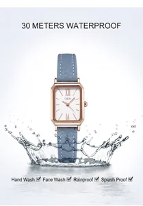 Détail d'une montre carrée en or rose avec bracelet en cuir bleu clair et effet d'eau
