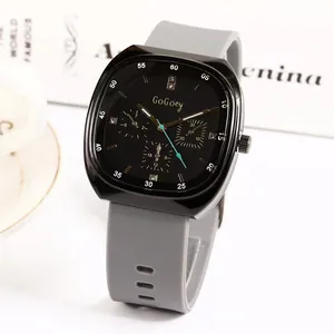 Fashion square sports watch with black dial and grey silicone strap on a desk background