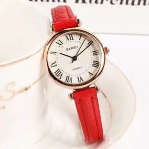 Macro detail of red leather strap and rose gold dial with Roman numerals on watch