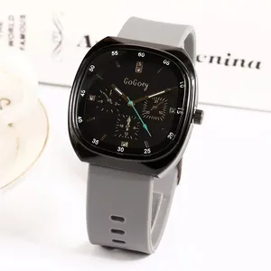 Close-up of square black quartz watch with grey silicone strap on a white surface