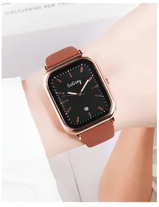 Détail d'une montre carrée en or rose avec cadran noir et bracelet marron au poignet